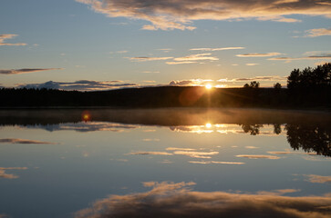 Sunset in a cloudy sky over the water surface
