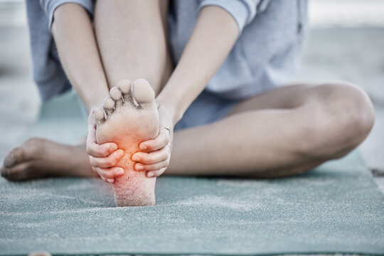 Foot, injury and pain with a woman holding her sole during fitness exercise with digital CGI or overlay. Workout, training and beach with a female athlete suffering from a sore joint or bone - Powered by Adobe