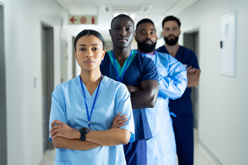 Portrait of diverse group of healthcare workers standing in line in hospital corridor