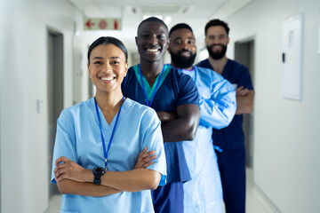 Portrait of diverse group of smiling healthcare workers standing in line in hospital corridor - Powered by Adobe