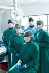 Vertical portrait of diverse group of surgeons ready for surgery in operating theatre, copy space