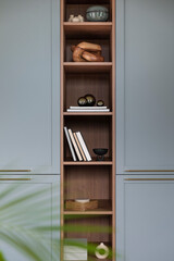 Minimalist composition of living room interior with wooden and blue bookcase, sculpture, books, glass balls, simple casket and personal accessories. Home decor. Template.