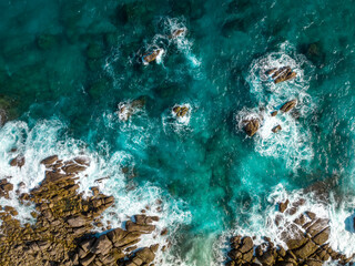 Aerial view Top down seashore. Waves crashing on rock cliff. Beautiful dark sea surface in sunny day summer background Amazing seascape top view seacoast at Intendance Beach, Mahe Seychelles