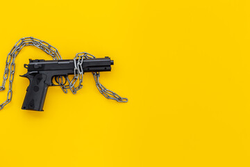 Hand gun weapon in chains. Ban on carrying weapons gun law concept