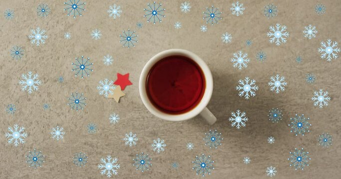 Animation of snow falling over christmas cup of tea