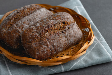 Fresh rye buns in a basket on a wooden table