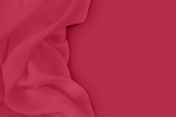 Trendy Color of the Year 2023. Viva magenta. Beautiful abstract silk fabric background. Abstract trendy red toned background with copy space. Flat lay