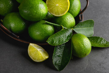 Fresh green limes with leaves on a tray