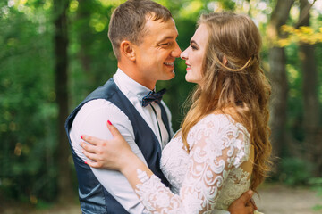 newlyweds smile and look at each other. profile of the bride and