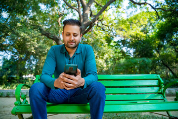 Indian man using smartphone at park