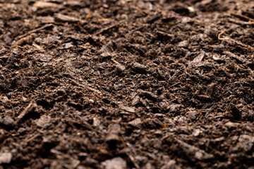 Full frame of dark rich peat soil and bark pieces