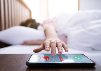 A woman wearing an eyepatch tries to touch her smartphone while waking up from sleep