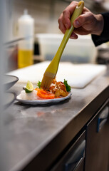 chef cooking slice salmon fish and shrimp with salad on kitchen