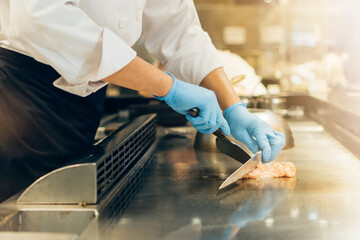 Hand of man take cooking of meat with vegetable grill, Chef cooking wagyu beef in Japanese teppanyaki restaurant