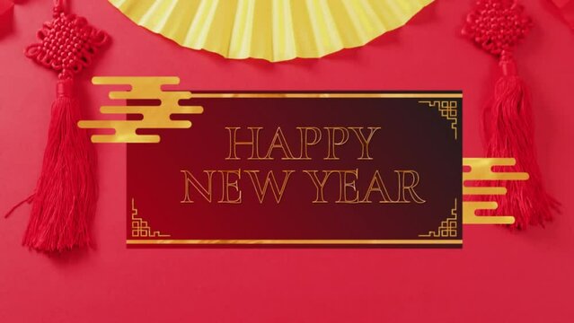 Animation of happy new year text over chinese traditional decorations on red background