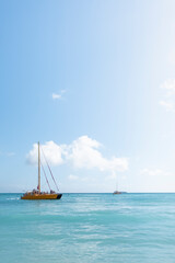 Fototapeta premium Catamaran boat on a clear sunny day sailing on the crystal clear blue ocean waves off the coast of Honolulu Hawaii