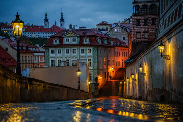Fototapeta na wymiar Famous Prague street Ke Hradu with shining lanterns in rainy autumn evening.