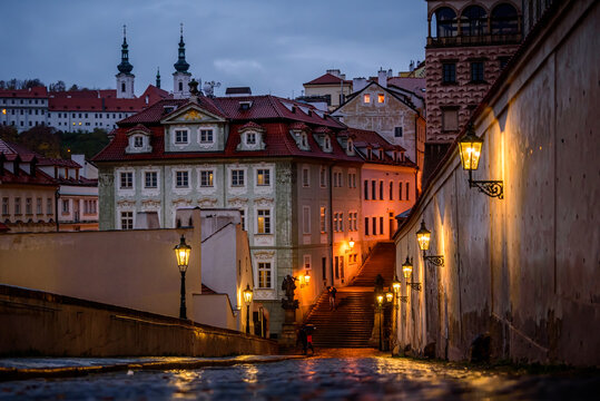 Famous Prague street Ke Hradu with shining lanterns in rainy autumn evening.