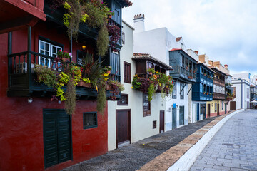Traditional colonial houses with typical Canary wood balcony decorated with many different flowers in Santa Cruz de La Palma, Canary island, Spain