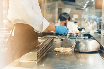 Hand of man take cooking of meat with vegetable grill, Chef cooking wagyu beef in Japanese teppanyaki restaurant