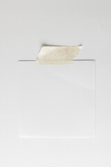 White sticky memo note with tape and copy space on white background
