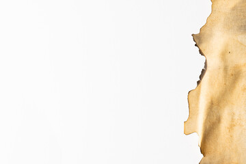 Burned and stained piece of paper with copy space on white background