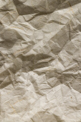 Vertical full frame image of crumpled, creased brown paper texture, with copy space