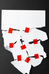 Foto op Plexiglas Ripped up pieces of white paper stuck together with red tape with copy space on black background © vectorfusionart