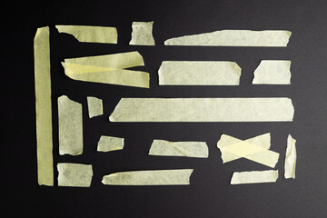 Ripped up pieces of masking tape with copy space on black background