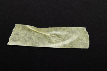 Ripped up piece of masking tape with copy space on black background