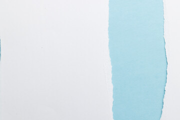 Obraz premium Ripped up pieces of white paper with copy space on blue background