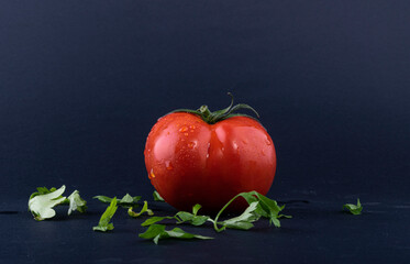 Tomato red. Tomatoes on a black background. Top view of tomatoes with Parsley leaf, side view.