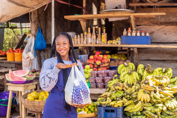 portrait of an african market woman smiling holding shopping bag