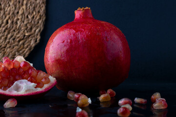 Healthy pomegranate fruit with leaves side view dark vintage background