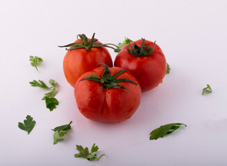 Tomato isolate. Tomatoes on a white background. Top view of tomatoes with Parsley leaf, side view.
