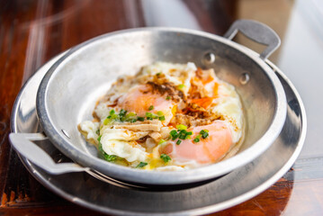Pan-fried egg with toppings in stanless pan, traditional Vietnam fried eggs food.