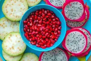 Pile of various types of fresh organic fruits (red berry strawberry, green apple, kiwi slice, orange and grapes fruit) isolated on wooden background. Healthy food boost immunity system concept.

