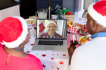 Senior african american couple having christmas video call with senior biracial man - Powered by Adobe