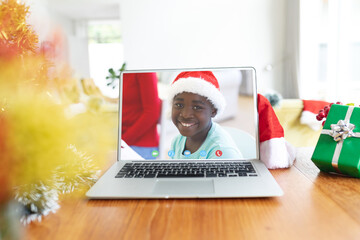 African american boy having christmas video call on laptop screen