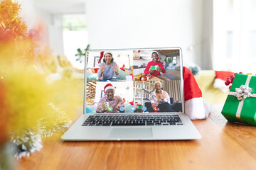 Happy diverse people with santa hats and christmas decorations having christmas laptop video call