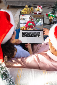 Biracial couple with christmas decorations having video call with happy african american man