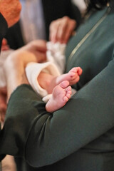 Feet of a newborn during the rite of baptism.