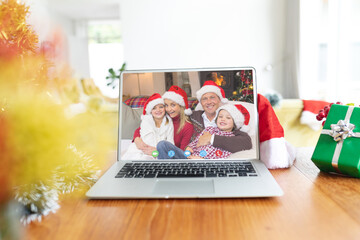 Happy caucasian family having christmas laptop video call on table