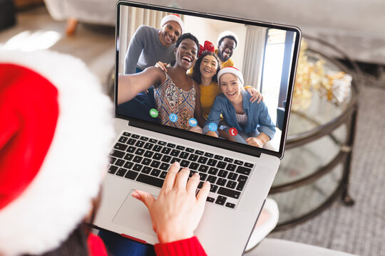 Caucasian woman with santa hat having video call with happy diverse friends