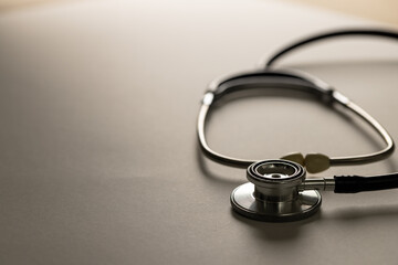 Composition of stethoscope on white surface with shadows, copy space