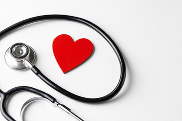Composition of stethoscope and red heart on white background with copy space