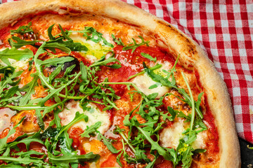 pizza with tomato, mozzarella and arugula, caprese pizza Italian pizza on a dark background, Fast food lunch. top view. place for text