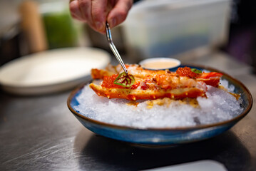 chef cooking crab legs with caviar on kitchen