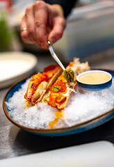 chef cooking crab legs with caviar on kitchen