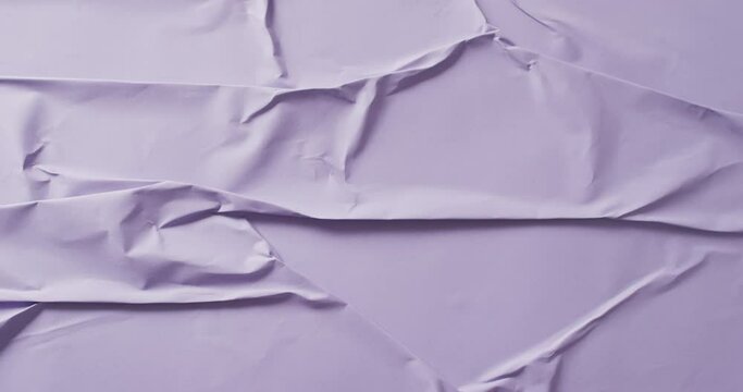 Video of close up of violet creased fabric with copy space